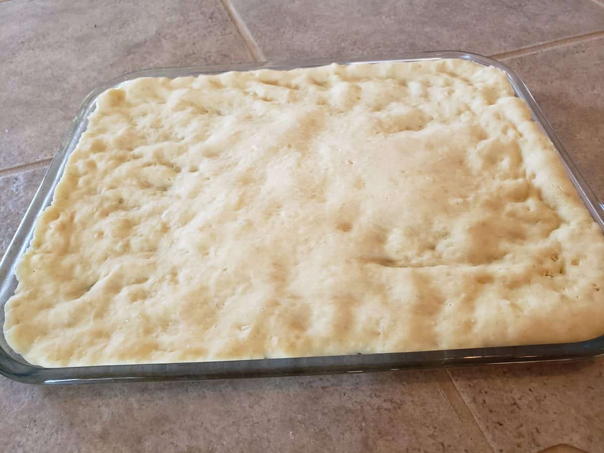 Bake the pizza crust in the oven for three minutes.