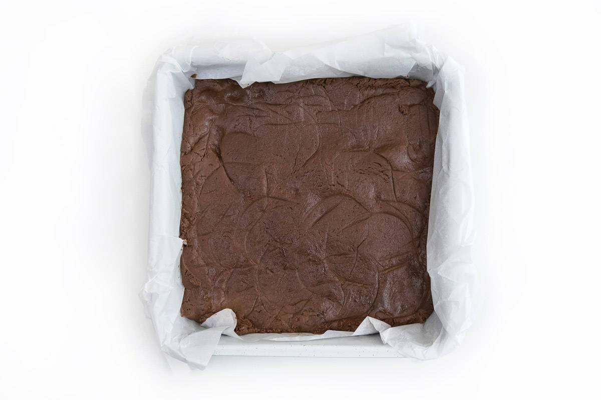 Line an eight inch baking dish with parchment paper. Pour the peanut butter chocolate chip mixture into the baking dish evenly.
