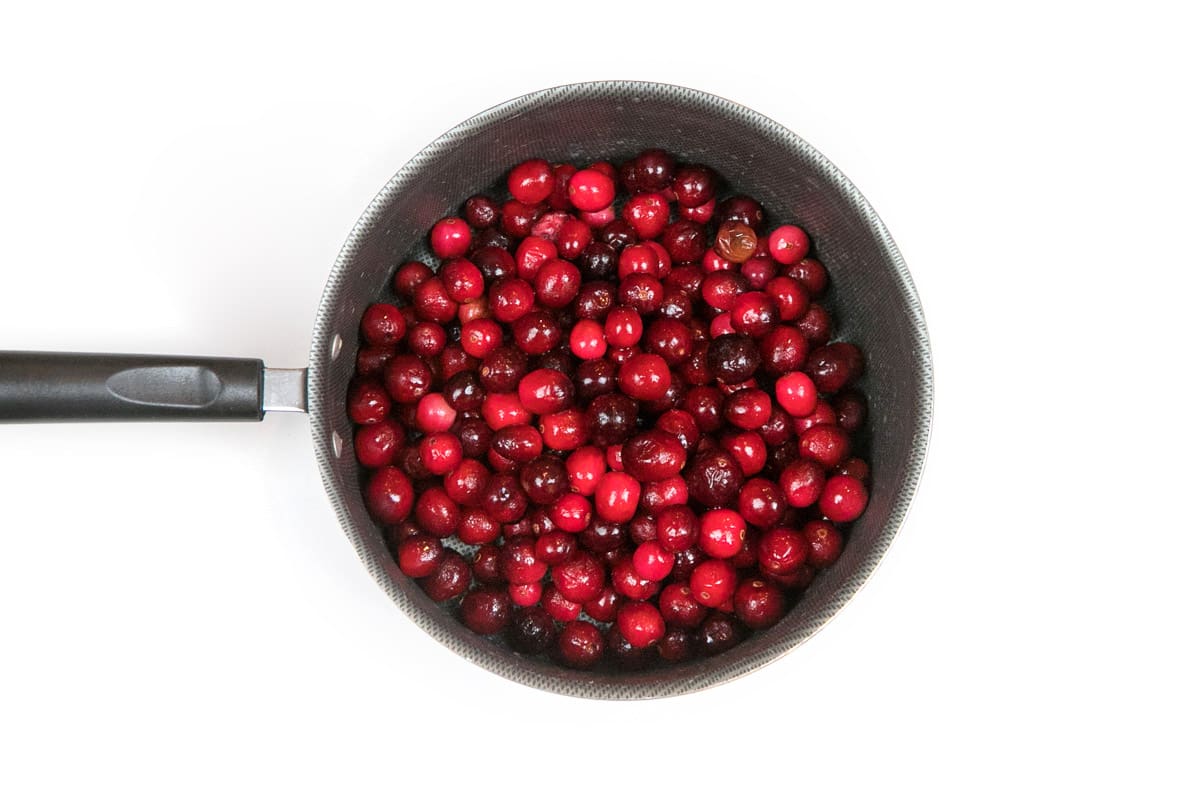 The rinsed frozen whole cranberries are put into a saucepan.
