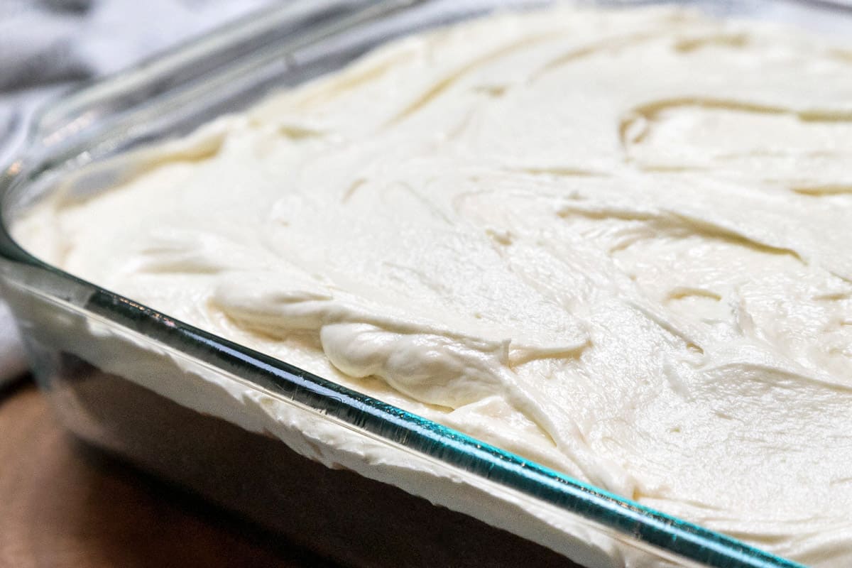 White chocolate buttercream frosting spread on a chocolate cake.