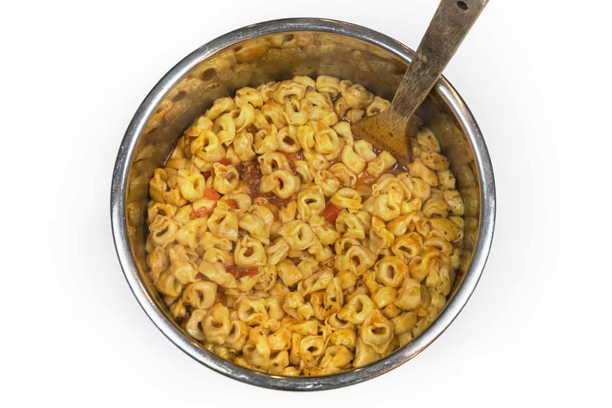 Tortellini pasta is mixed with the browned ground beef, pasta sauce, and diced tomatoes.