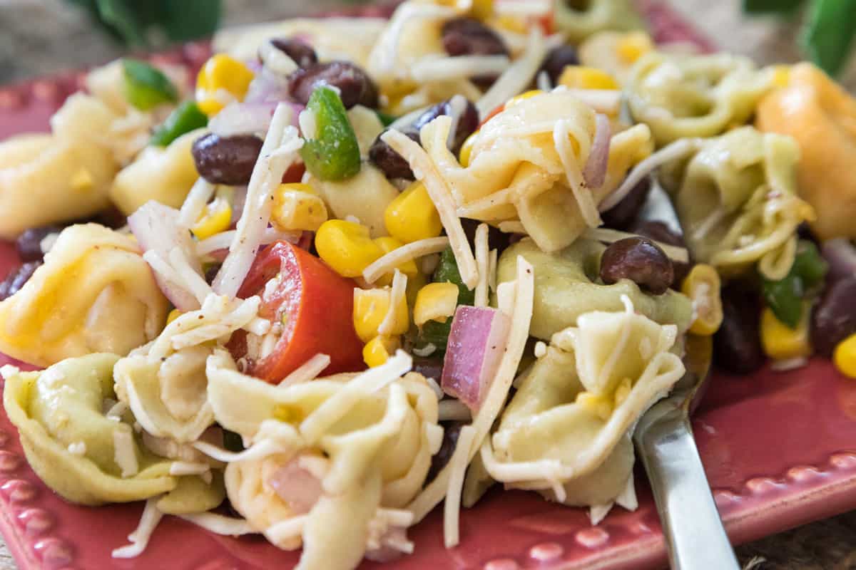 A serving of summer tortellini salad with corn salsa on a plate.