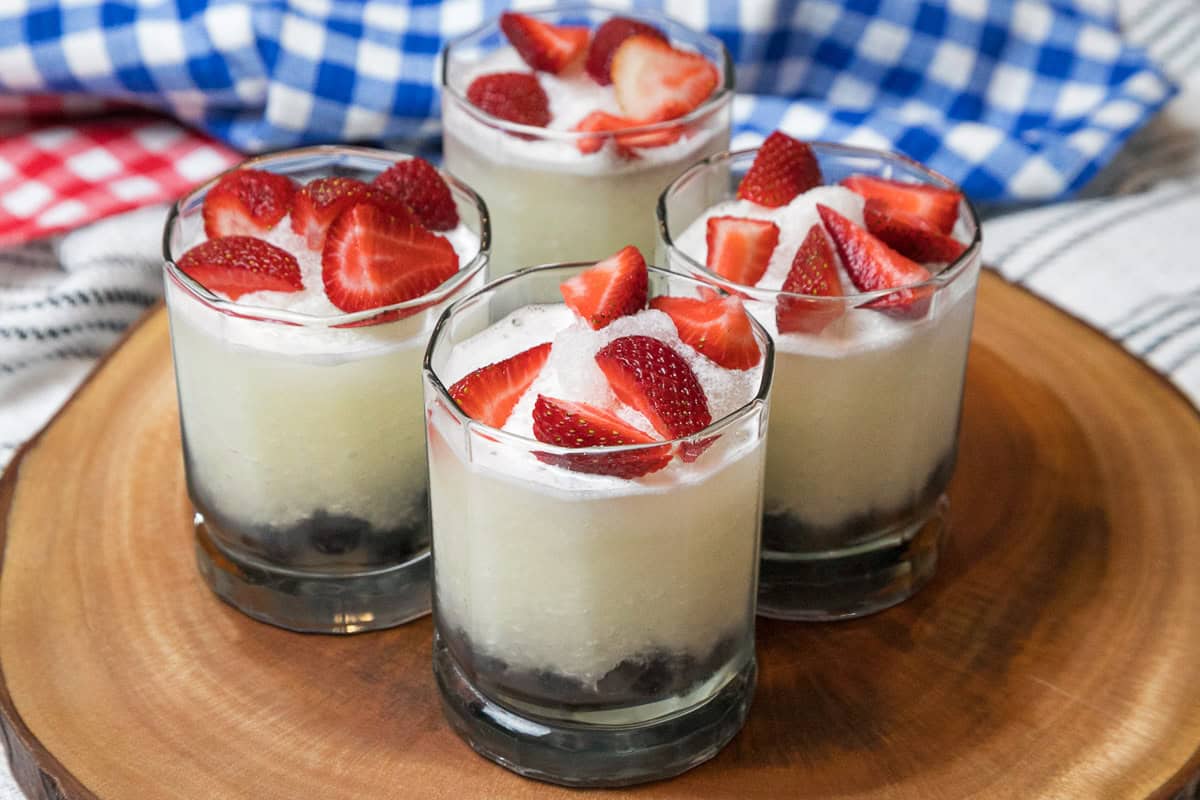 Sliced strawberries are arranged on top of the lemonade.