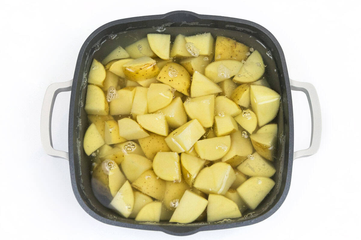 Cut potatoes in a saucepan with water.