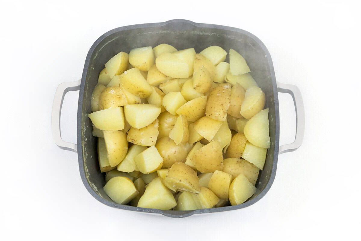 Drain water from cooked potatoes.