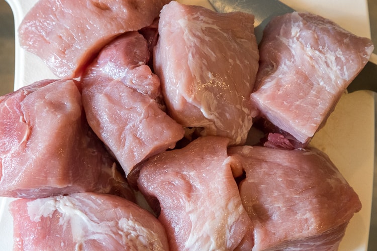 Chunks of pork on a cutting board.