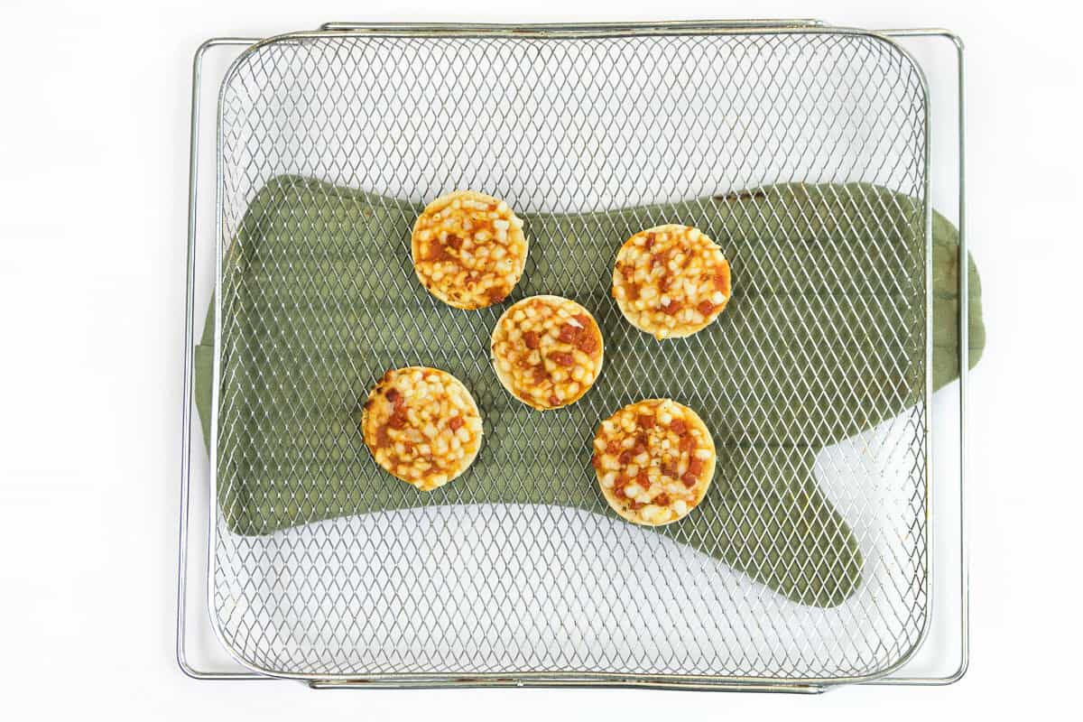 Cook the mini pizza bagels in the air fryer for about ten minutes.