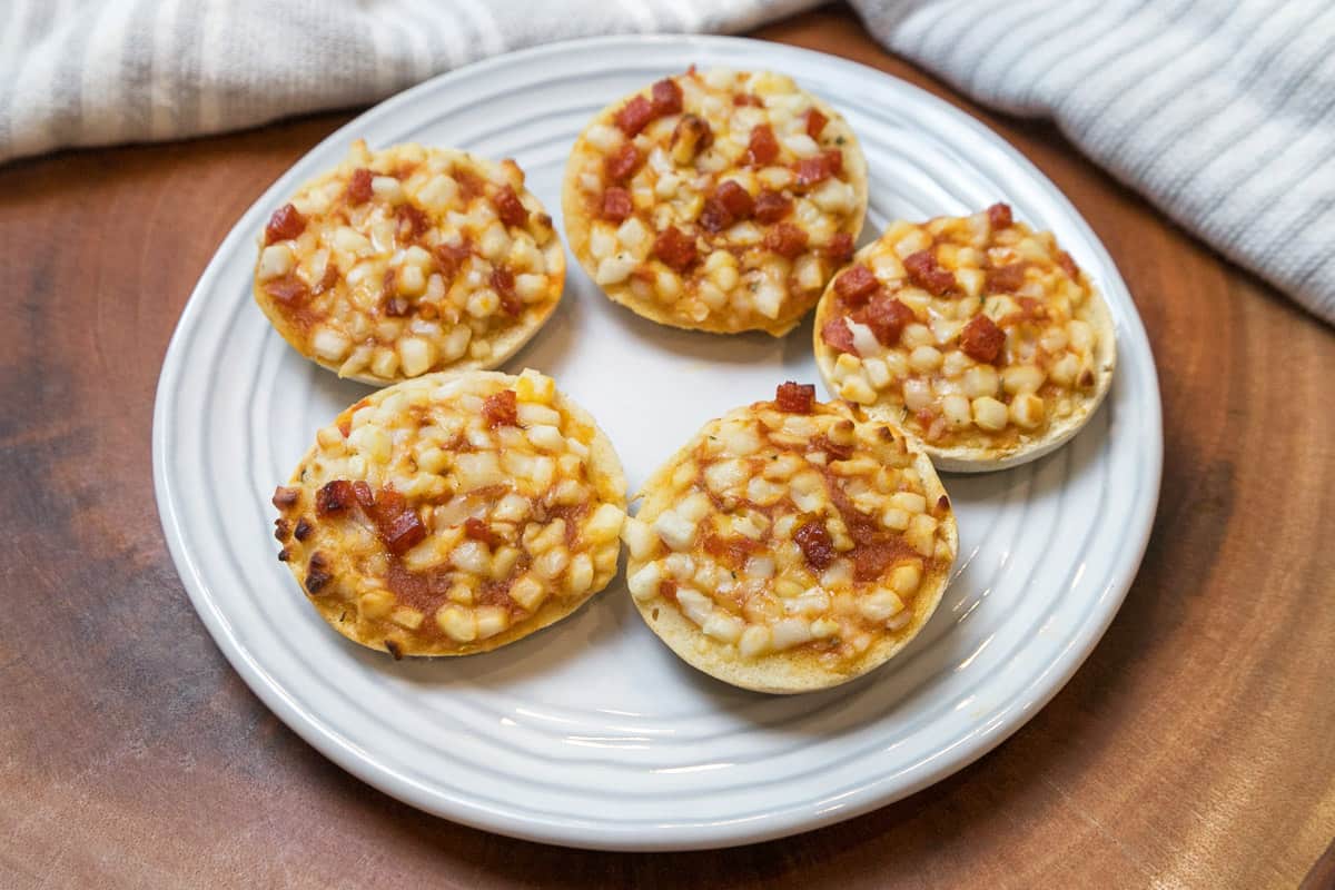 Air fryer frozen mini pizza bagels on a plate.