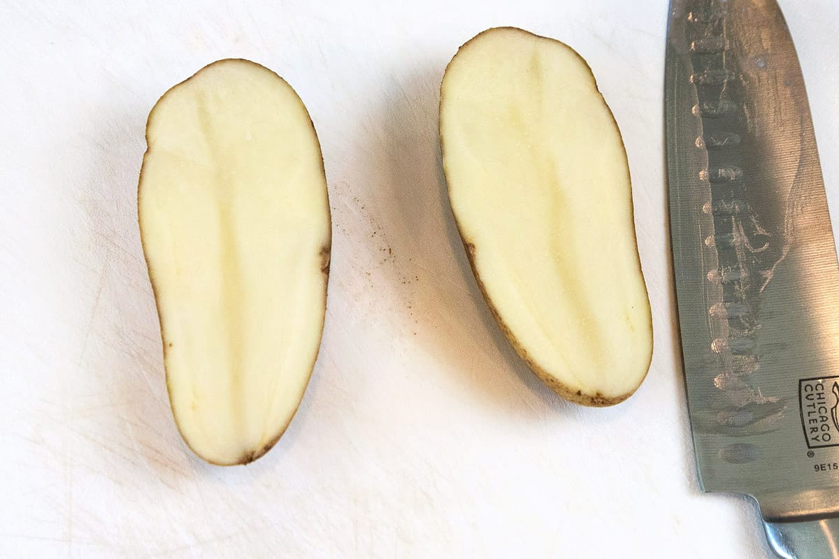 A potato cut in half, lengthwise.