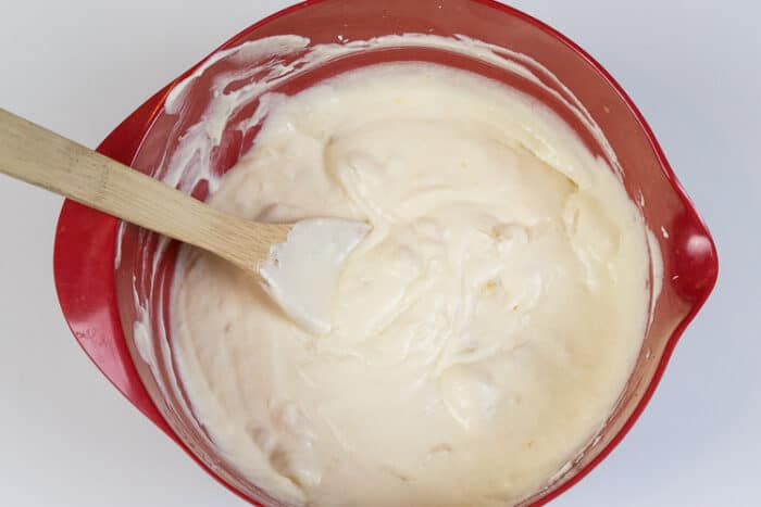 The vanilla extract, four bananas, eggs, melted butter, cream cheese, and sugar are mixed thoroughly together.