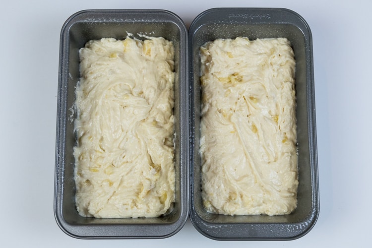 Two loaf pans filled with banana bread batter.