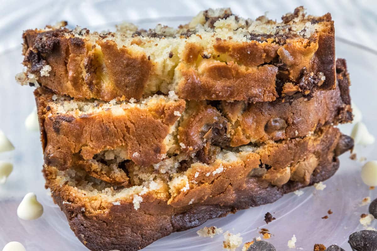 Three slices of banana bread with cream cheese and chocolate chips on a plate.