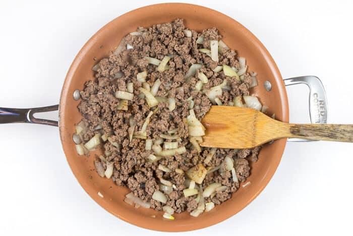 Add the ground beef in with the onion and cook on medium-high heat until there is no pink in the ground beef.