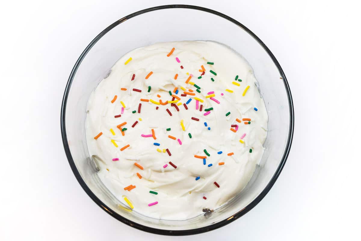 Spread half of the cheesecake cream cheese pudding mixture over the top of the cake pieces and then shake sprinkles on top.