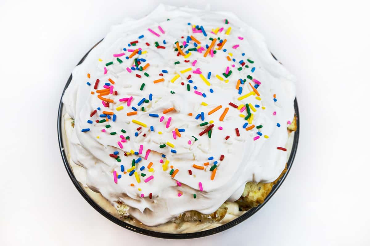 For the last layer, spread the rest of the whipped topping on top of the cake pieces, then more sprinkles.