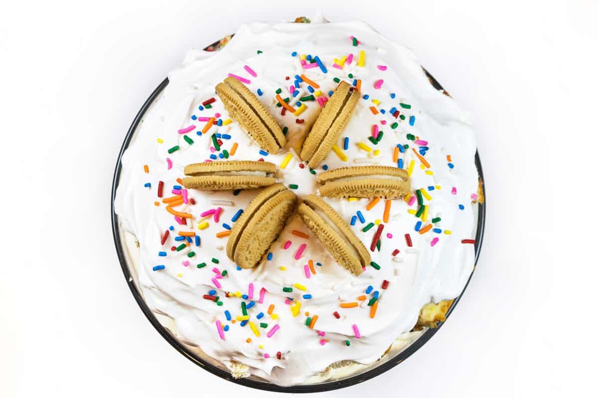 Place six cookies around the top of the birthday trifle cake with sprinkles.