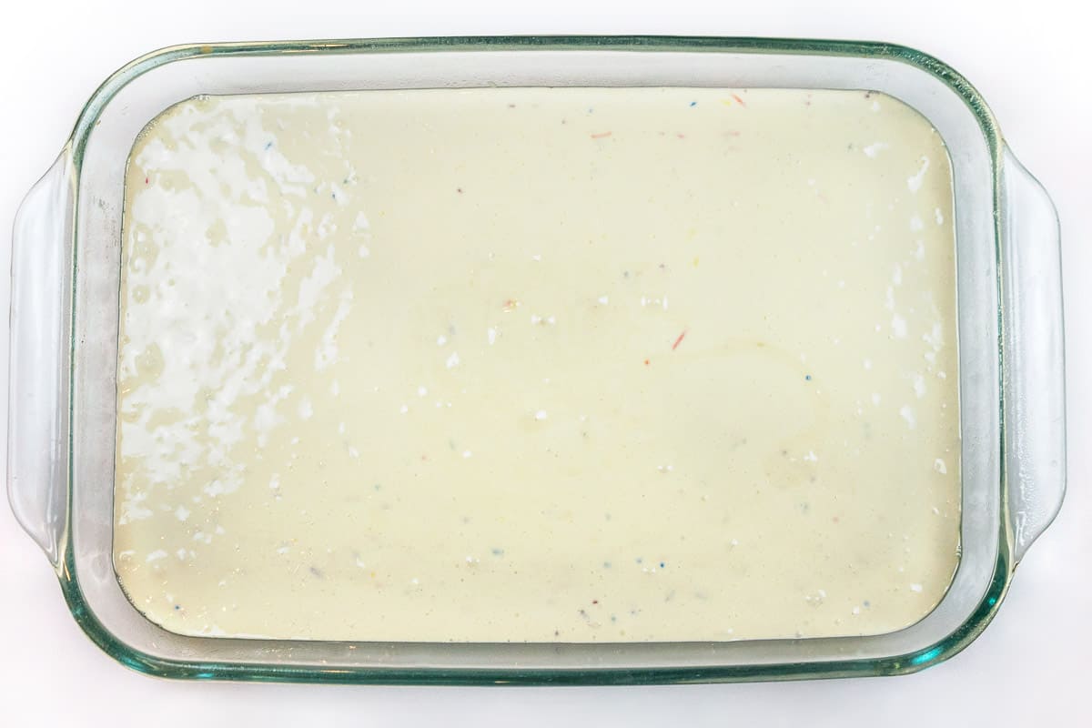 The cake batter is poured into a nine by thirteen inch greased baking pan.