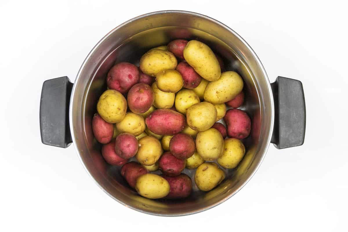 Baby potatoes in a pot of water.