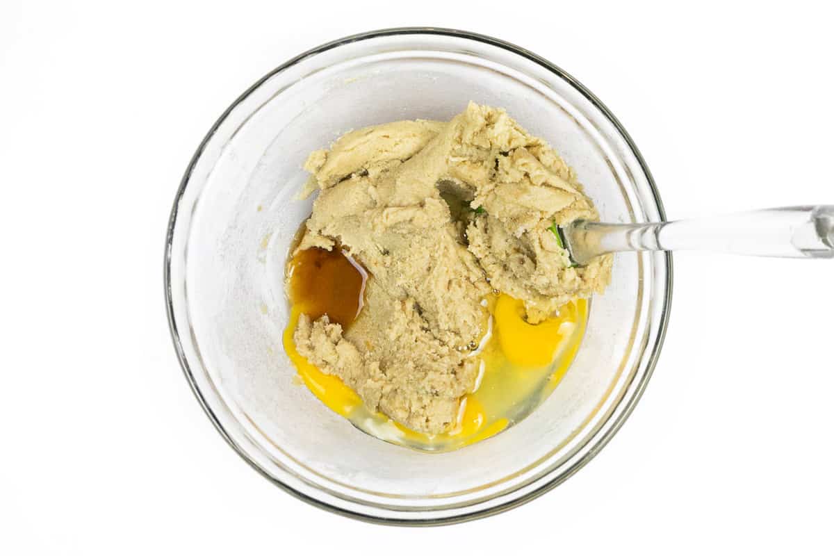 The eggs and vanilla extract are added to the softened butter, granulated sugar, and light brown sugar.