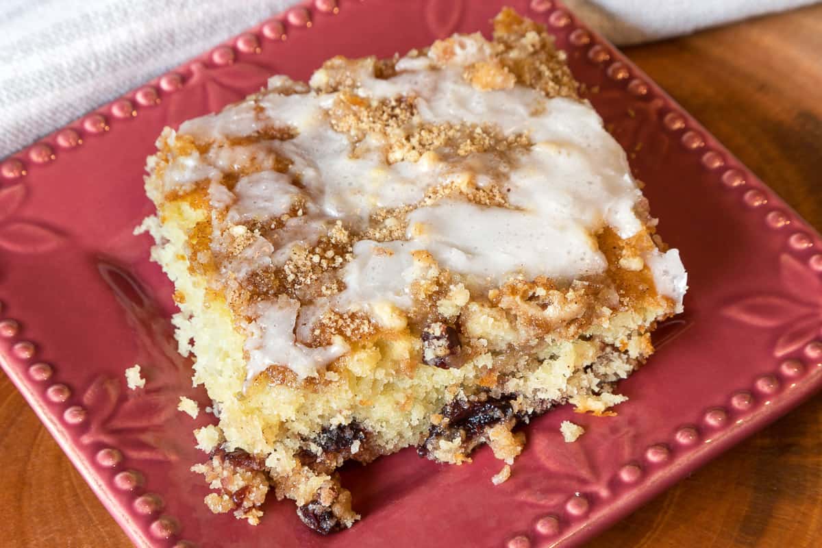 Cherry coffee cake on a plate with glaze topping.