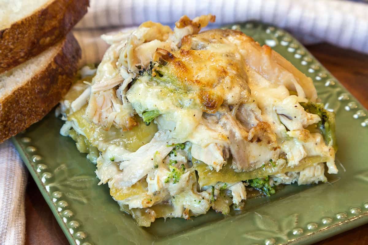 A close-up photo of a slice of chicken and broccoli lasagna on a plate.