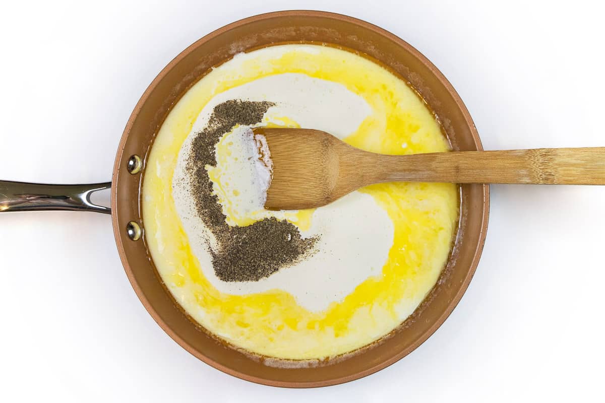 Add the heavy cream and black pepper to the melted butter and garlic.