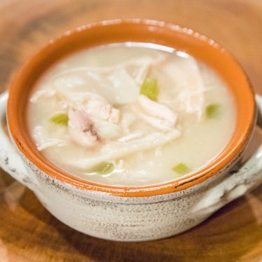 Chicken and dumpling soup in a bowl close up.