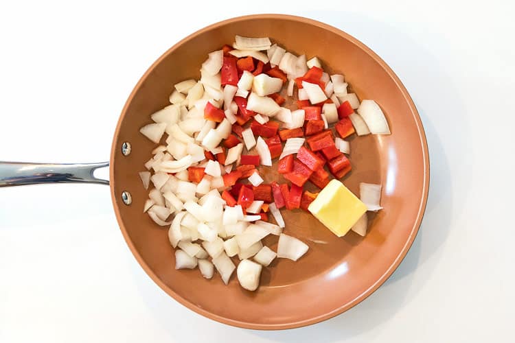 One diced red pepper, one diced onion and two tablespoons of butter in a skillet.