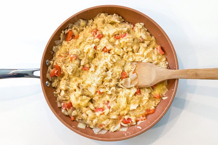 Cream of chicken soup is added to the frying pan.