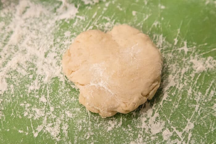 Flour dough on cutting board sprinkled with flour.