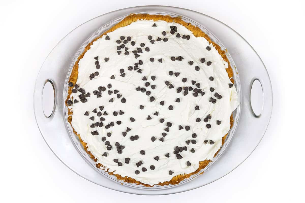 Mini chocolate chips are sprinkled on top of the whipped cream on the chocolate pie.