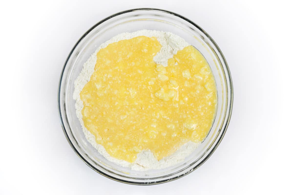 The melted butter mixture is added to the flour mixture.