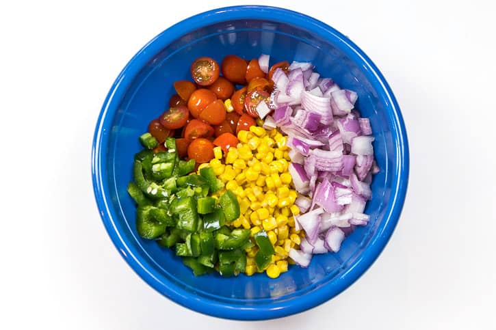 Put the corn, tomatoes, jalapenos, and the red onions in a bowl and season with salt, pepper, and lemon juice.