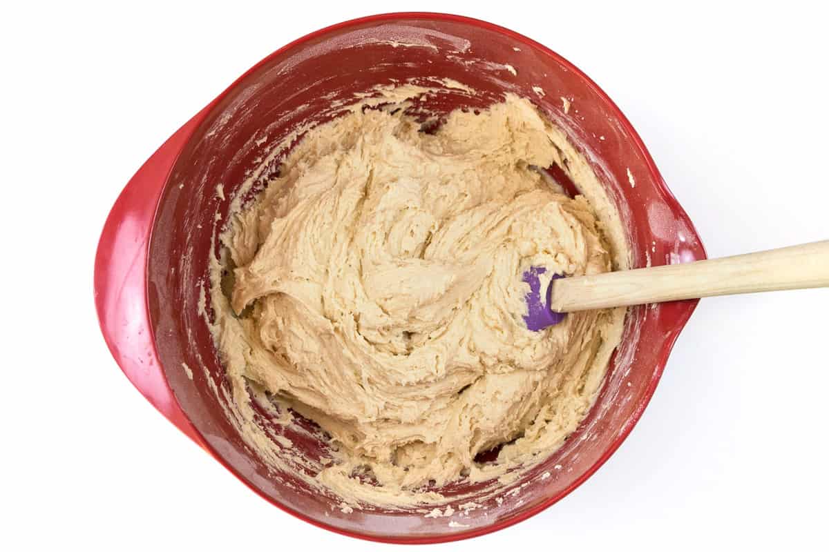 The flour mixture and the cookie dough are blended together in the bowl.