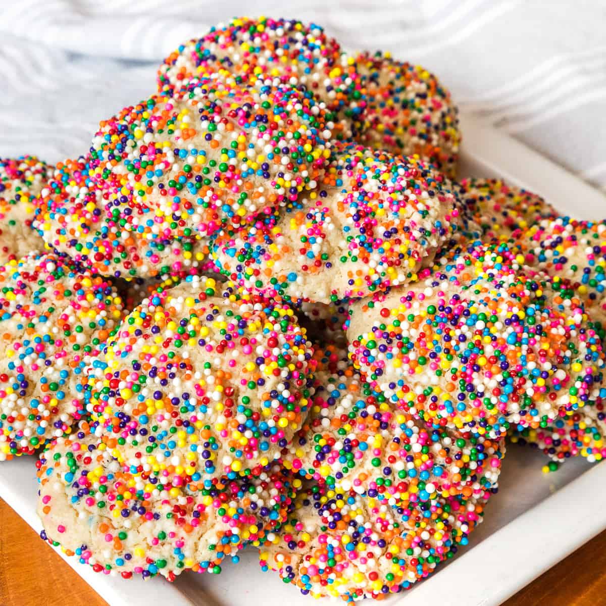 Colorful cream cheese cookies with sprinkles on a plate.