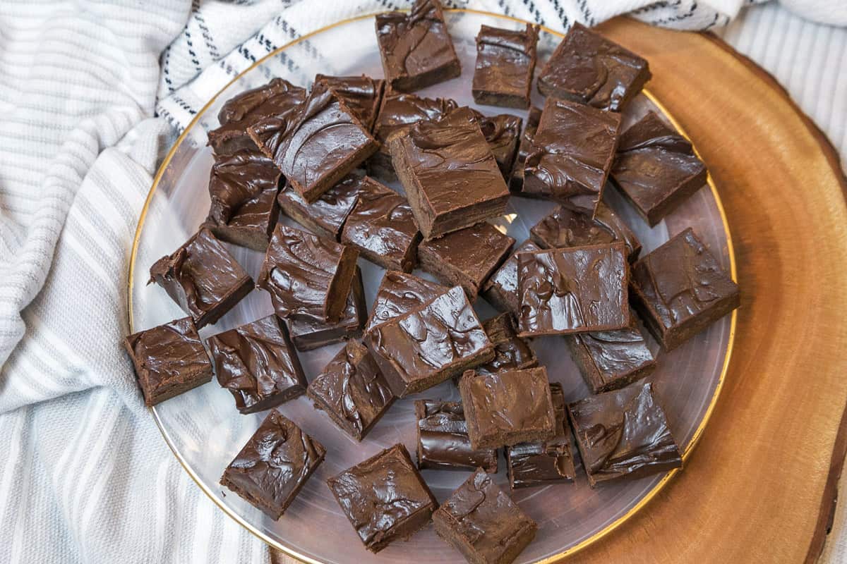 Dark chocolate fudge cut into squares on a plate.