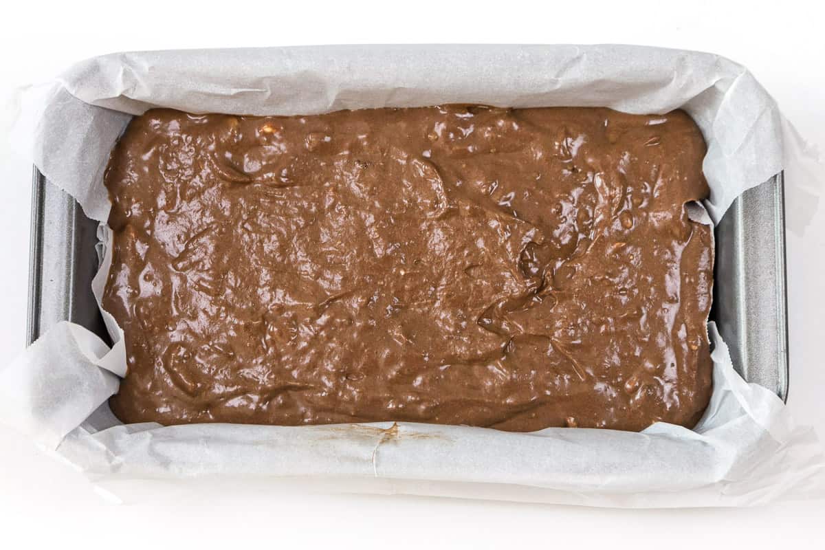 Pour the banana bread batter into a loaf pan lined with parchment paper..