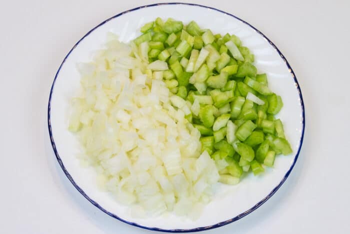 Diced onion and celery on a plate for the Thanksgiving dressing.