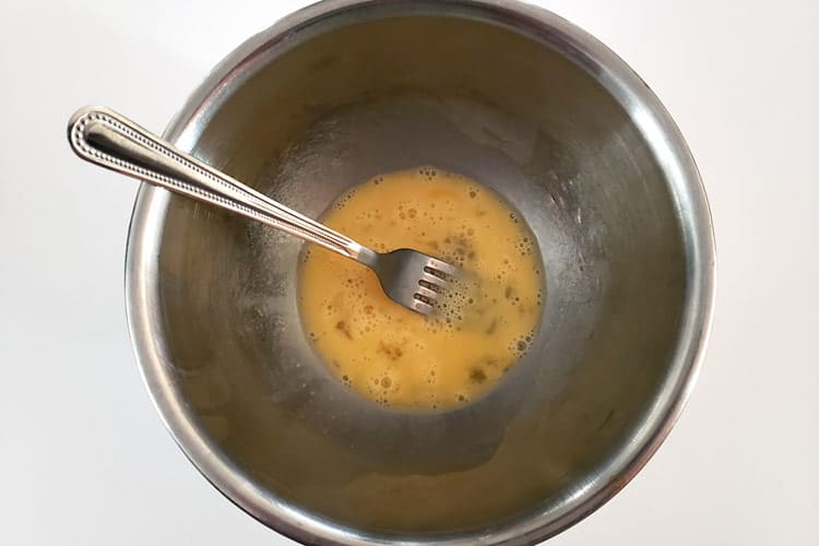 One beaten egg in a bowl.