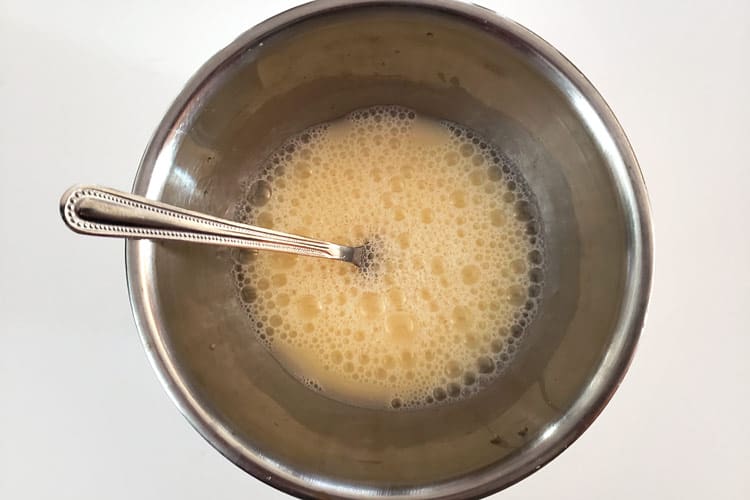 Add three-fourths cup of water to the beaten egg.