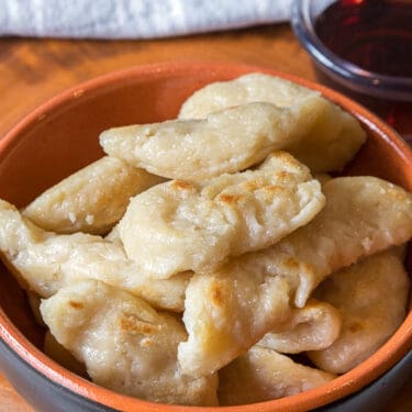 Dumplings with syrup in a bowl, close up.