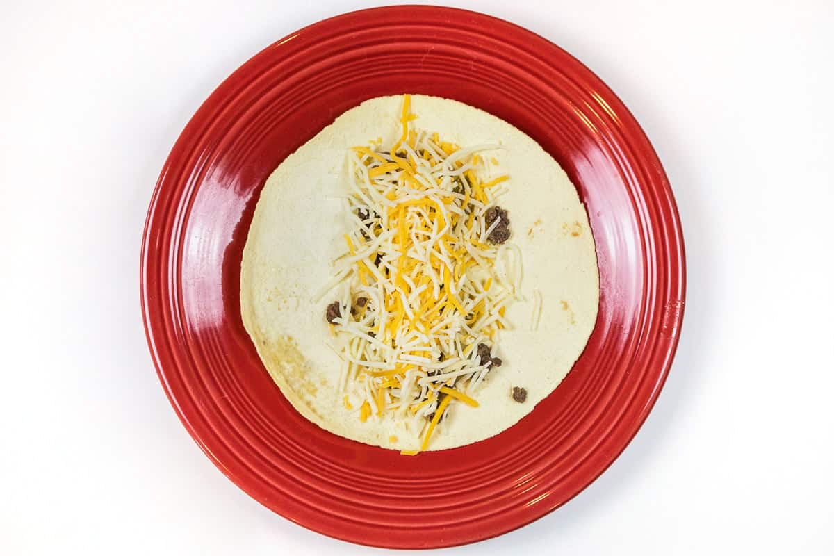 Add some Mexican cheese blend on top of the ground beef and green chiles.