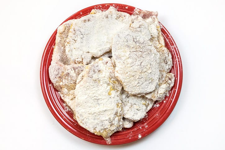 Repeat dipping all of the other pork chops into the beaten eggs and flour mixture.