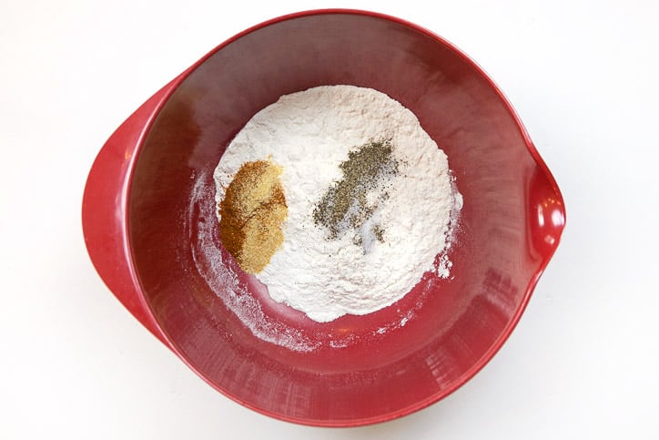 Flour, salt, pepper, garlic powder, creole seasoning, and cayenne pepper in a bowl.