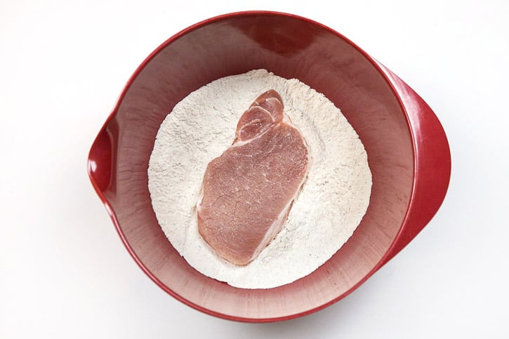 Put one pork chop in the flour mixture.