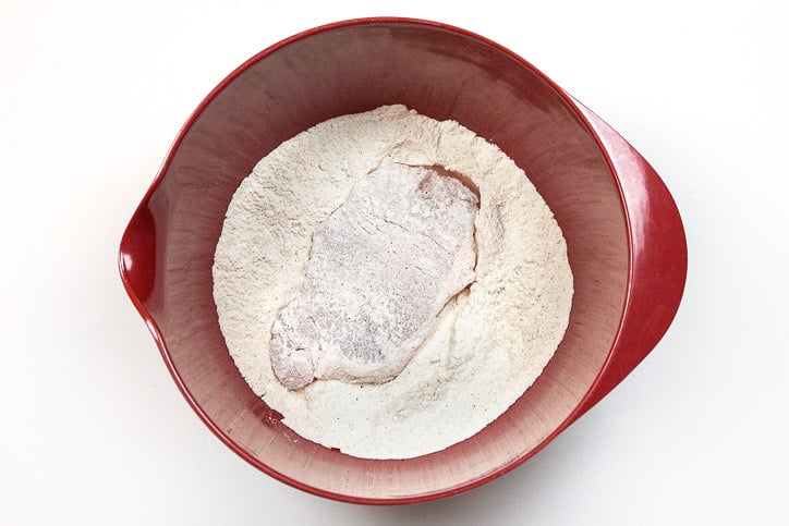 Flip the pork chop over to get flour on the other side.