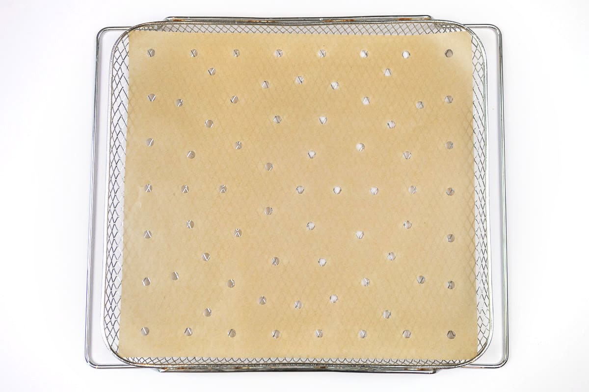 Put parchment paper with holes in it or brush on oil or cooking spray on the air fryer basket.