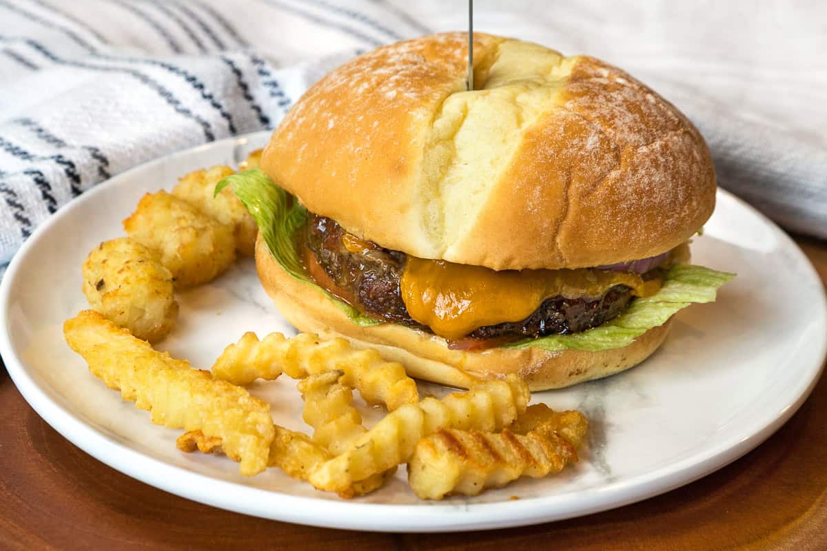 A hamburger with all of the trimmings on a plate.