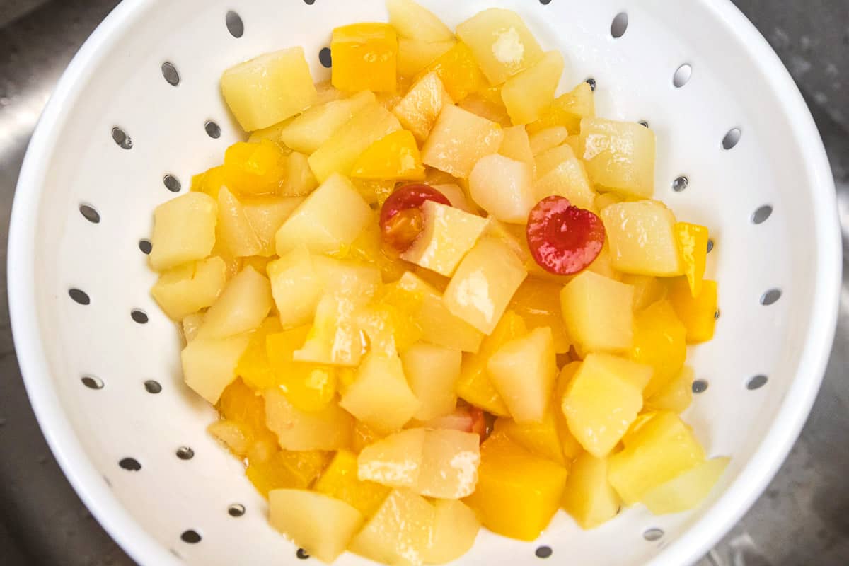 Fruit cocktail drained in a colander.