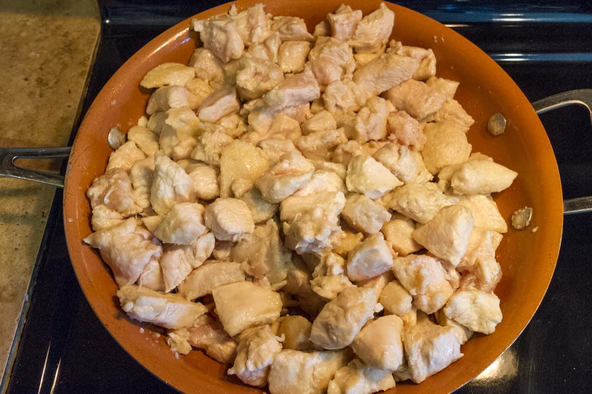 Frying the chicken in the frying pan for forty-five minutes.